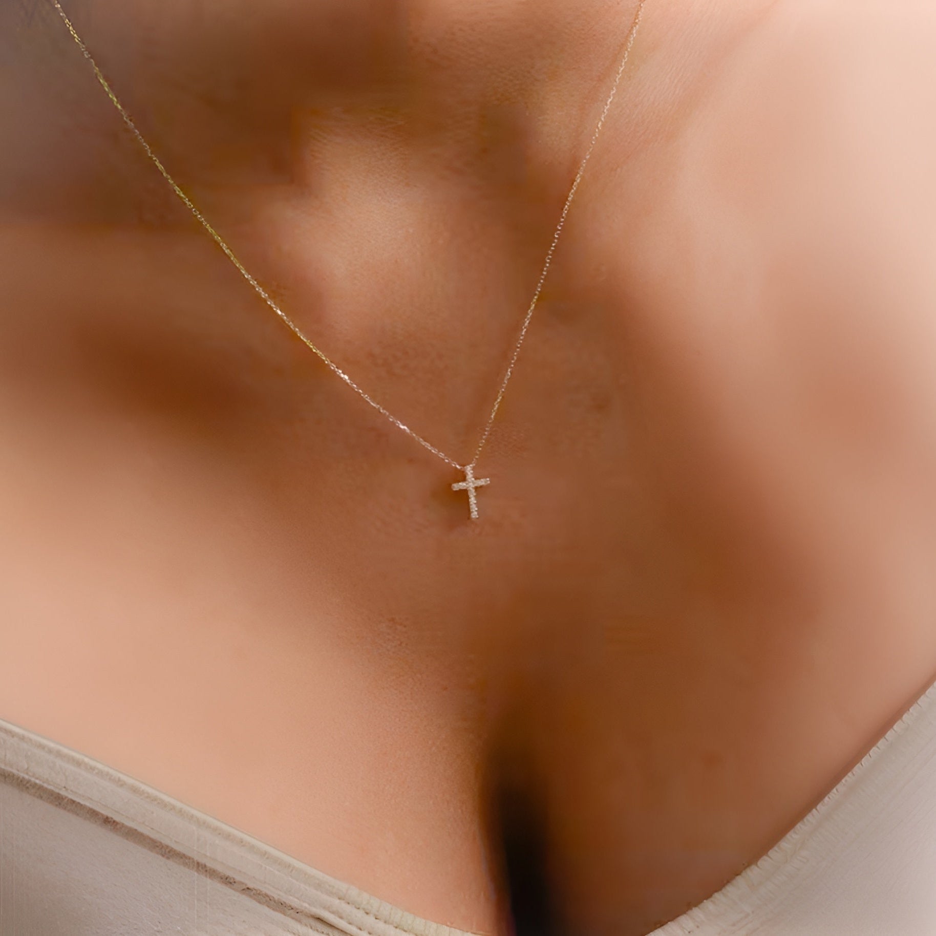 Gold necklace with a small cross pendant on a person's neck. 18K gold-plated dainty cross necklace with gift box.