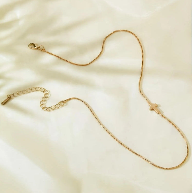 Gold chain necklace on a beige fabric background