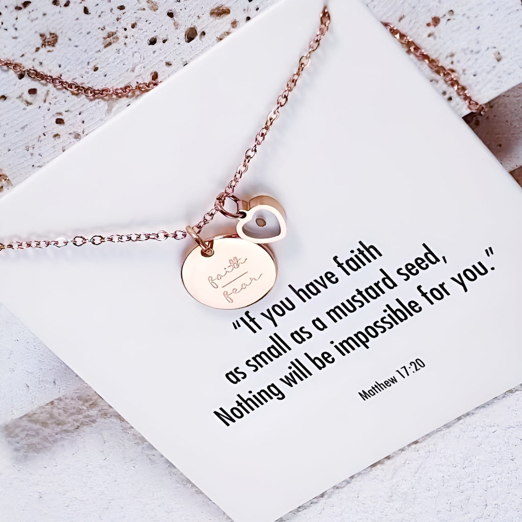 Rose gold necklace with heart pendant and inspirational quote card on a textured surface. Christian Jewellery UK.