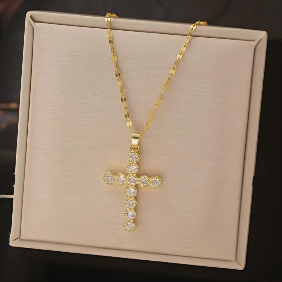 Gold cross necklace with diamonds on a beige display box