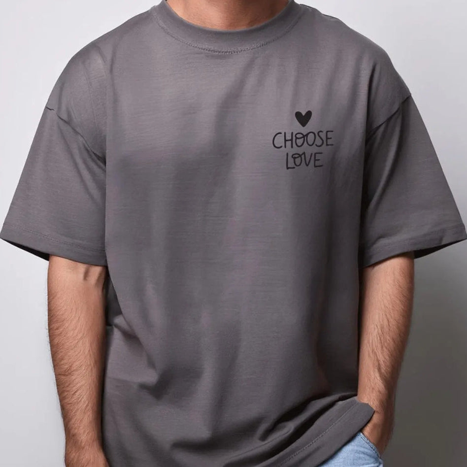 Person wearing a gray t-shirt with 'CHOOSE LOVE' text on a plain background