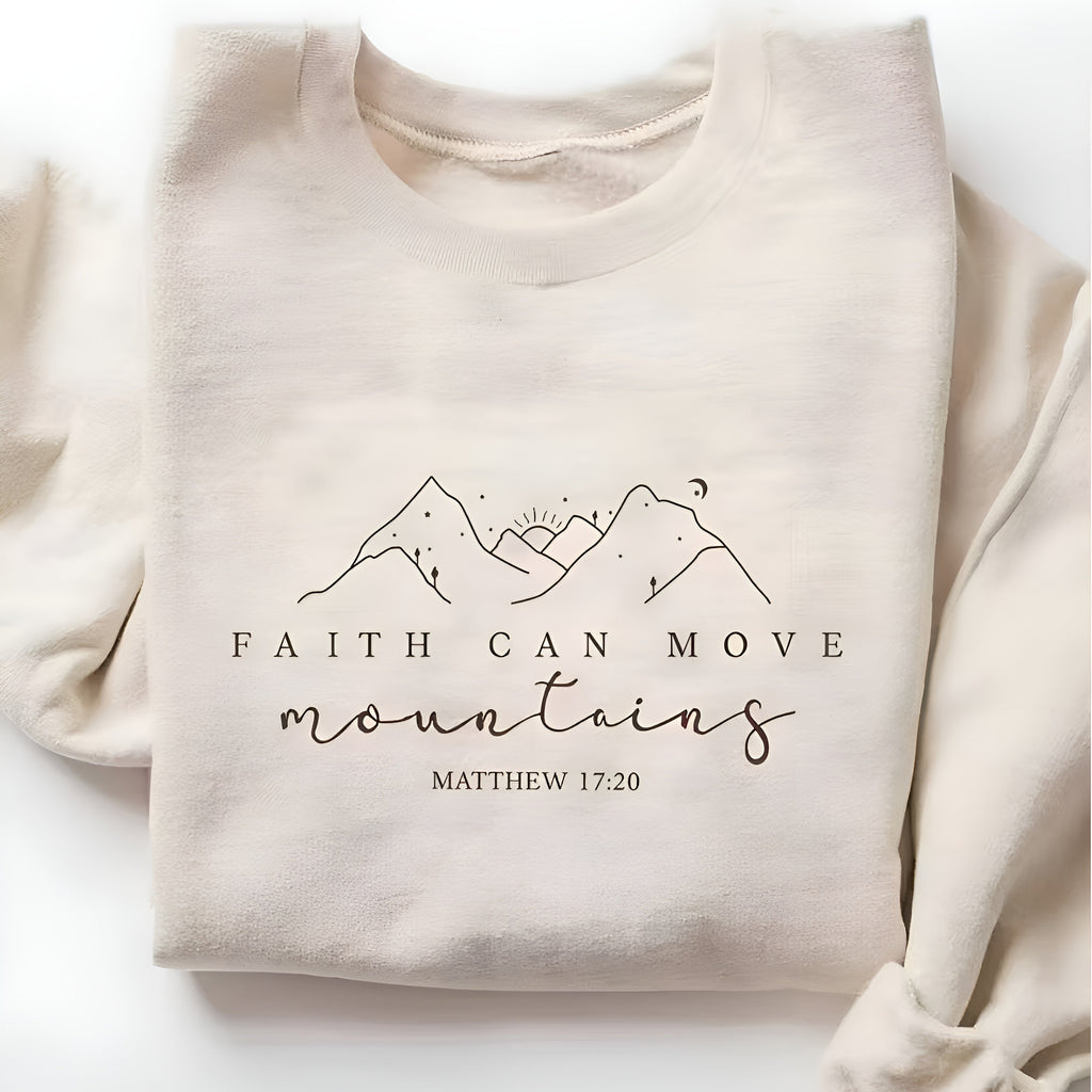 Beige sweatshirt with 'Faith can move mountains' text and mountain design on a white background