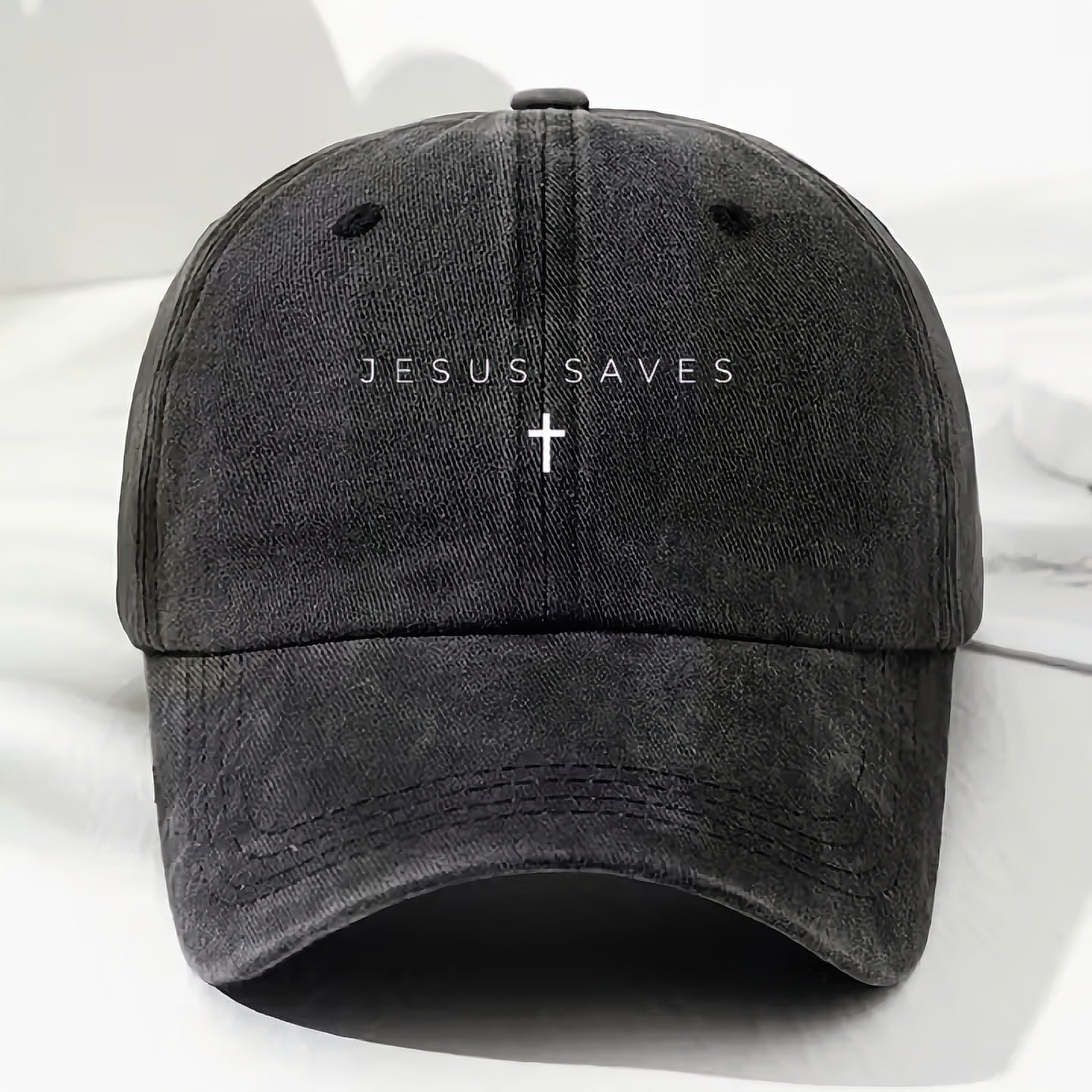 Black cap with 'Jesus Saves' text and cross on a white background