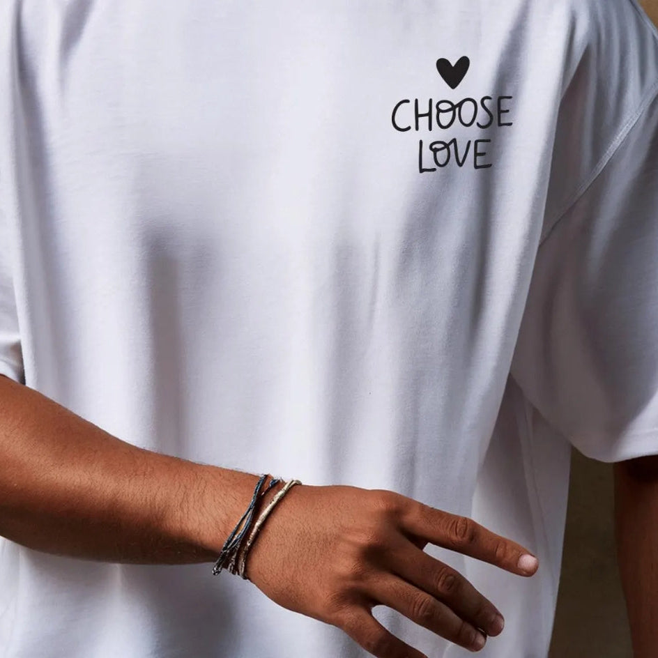 White t-shirt with 'CHOOSE LOVE' text and heart symbol on a plain background