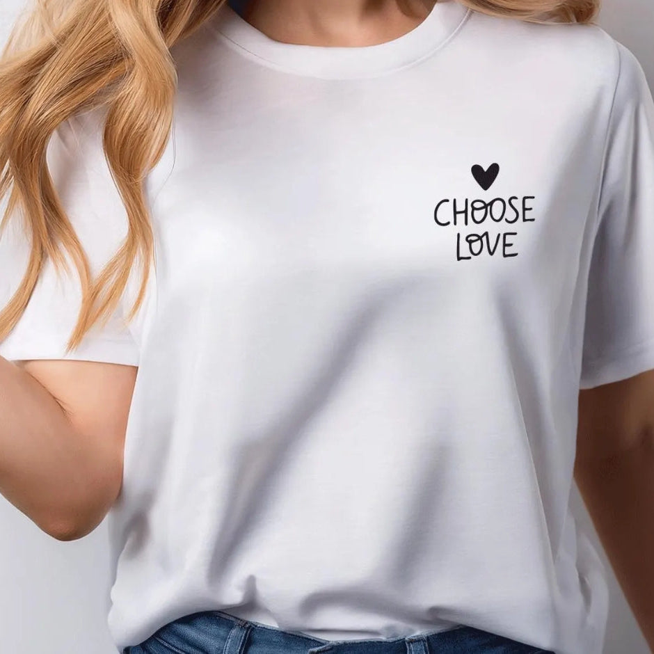 White t-shirt with 'CHOOSE LOVE' text and heart symbol worn by a person.
